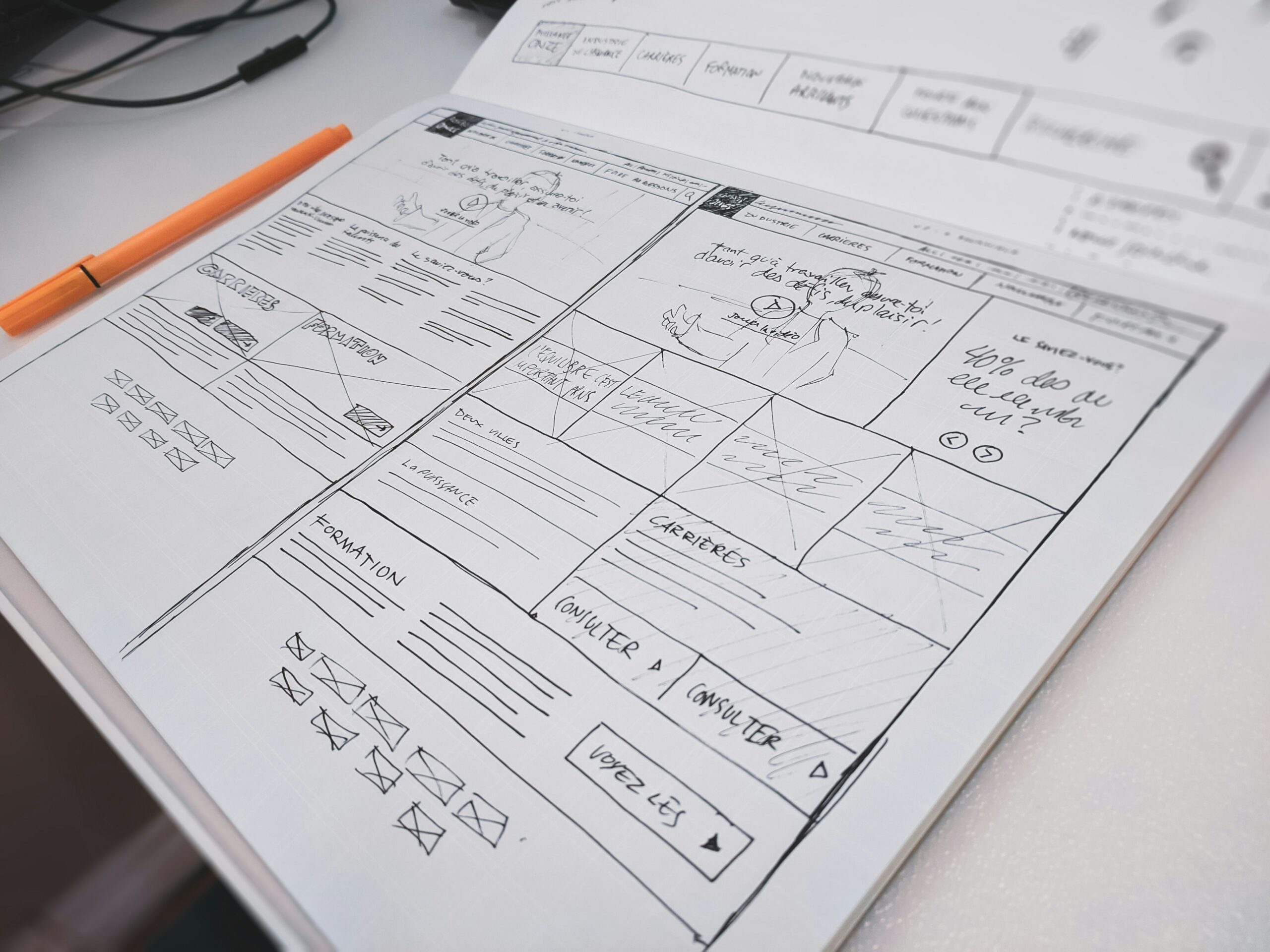 Sketched page layouts and planning notes in a notebook