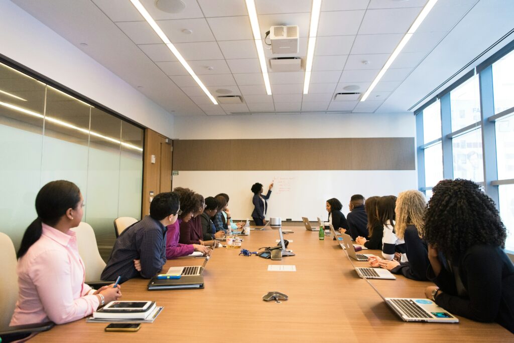 Trainer presenting at a whiteboard to a group in a meeting room