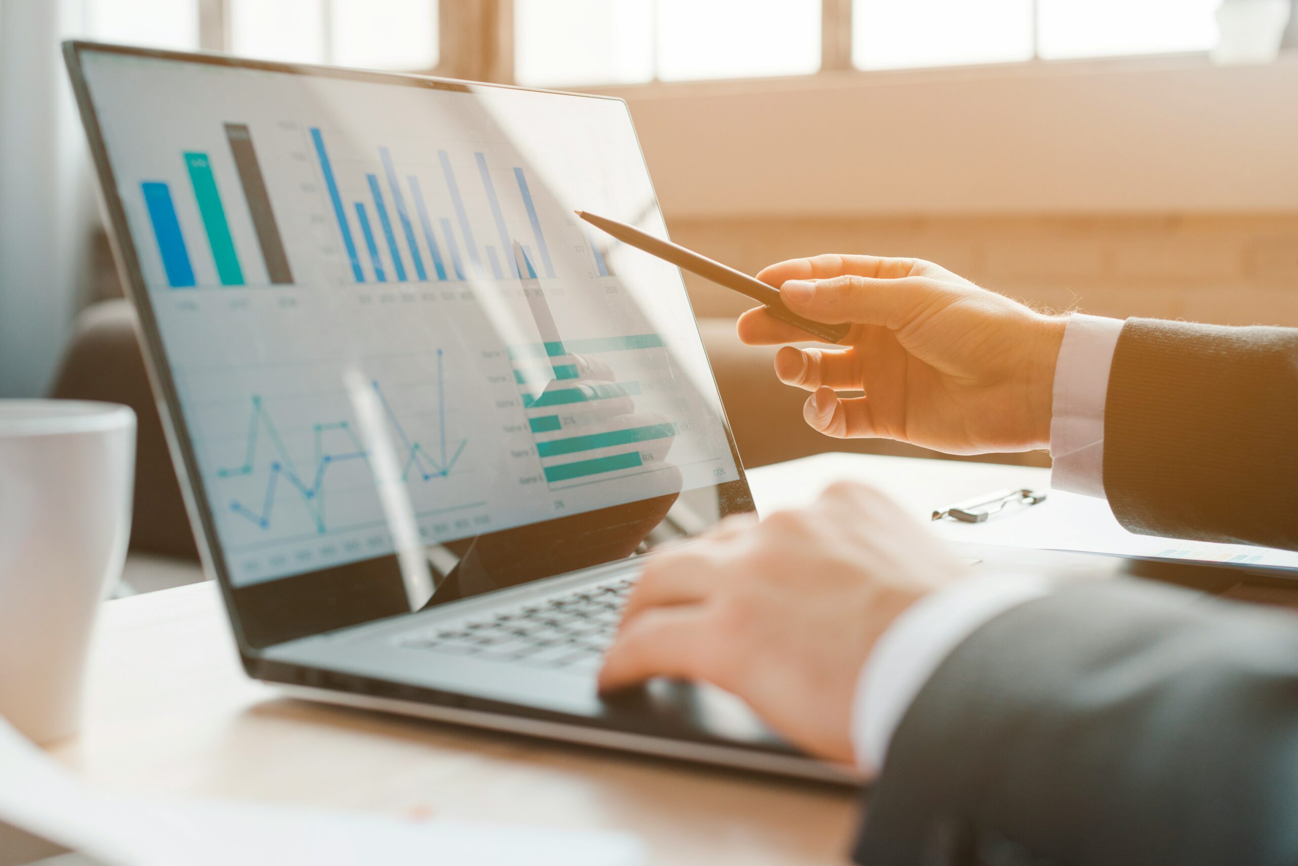 Business analyst reviewing charts on a laptop