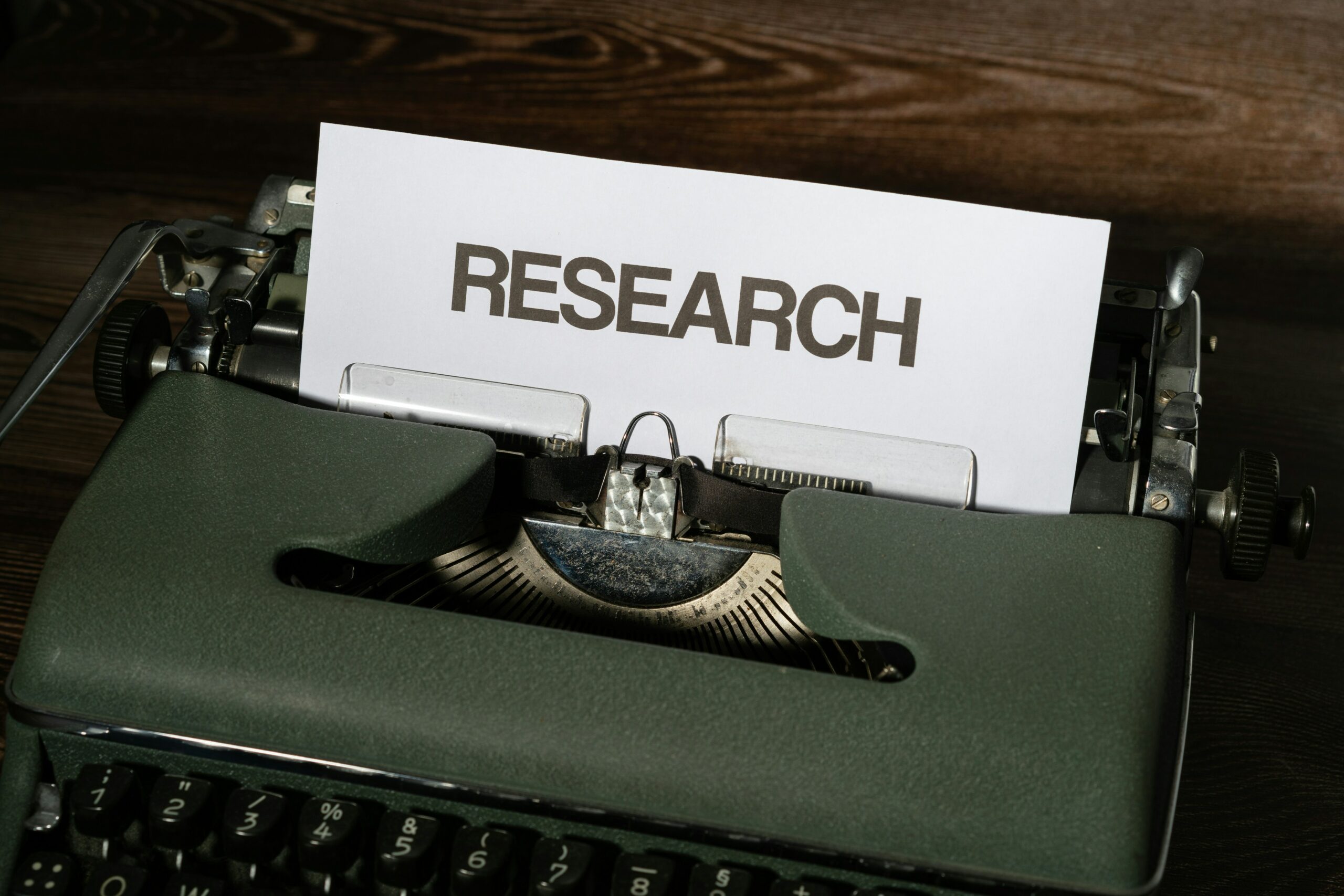 Typewriter with a sheet of paper reading "Research"